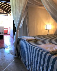 阿拉亚尔达茹达Ouro Sobre Azul Apart Hotel的一间卧室配有一张带蓝白条纹毯子的床