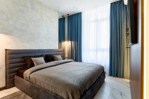 基辅KADOR HOME HOTEL downtown的一间卧室配有一张带蓝色窗帘的大床