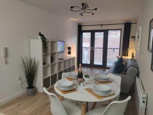 利物浦Fantastic centrally located 1 bed apartment的用餐室以及带桌椅的起居室。