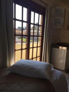 拉热斯Villa Apart Hotel的一张位于带大窗户的房间内的床铺