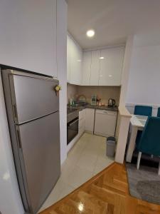 卢卡维卡Apartman Victoria的厨房配有不锈钢冰箱和桌子