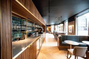 伦敦Wilde Aparthotels London Aldgate Tower Bridge的餐厅设有酒吧,配有桌椅