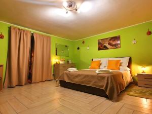 那不勒斯Maison Zazà Naples的一间卧室设有绿色的墙壁和一张带橙色枕头的床