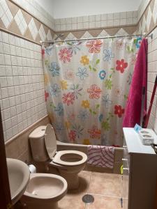 弗龙特拉El Hoyo的浴室设有卫生间和鲜花淋浴帘