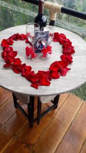佩雷拉Glamping Casa Viva的红玫瑰心和酒杯的桌子