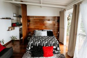 佩雷拉Glamping Casa Viva的一间卧室配有一张带黑色和红色枕头的床