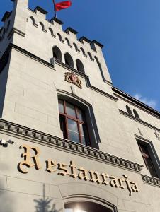 比斯Hotel i Restauracja Castle的建筑的侧面有标志