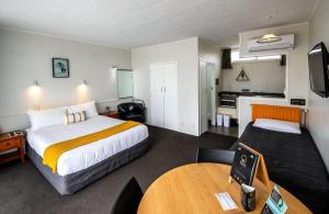 罗托鲁瓦灵气公寓的酒店客房设有一张大床和一张桌子。