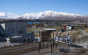 特卡波湖Alpine View Apartment 2 - Tekapo的甲板上配有桌椅,甲板上设有雪覆盖的山脉