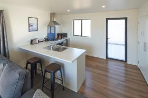 特卡波湖Alpine View Apartment 2 - Tekapo的厨房配有水槽和带凳子的台面