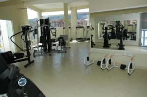 热河市APARTAMENTO ÁGUAS DA SERRA - 005b的健身房设有数台跑步机和镜子