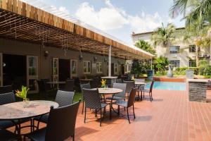比勒陀利亚ANEW Hotel Capital Pretoria的一个带桌椅的庭院和一个游泳池