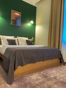 新库兹涅茨克G.S.宾馆的一间卧室设有一张大床和绿色的墙壁