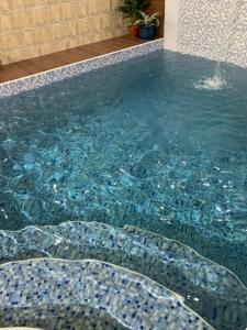 Al Wāşil东方之夜酒店的一个带马赛克瓷砖地板的游泳池和一个游泳池