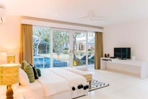 金巴兰CassaMia Bali - Spacious Luxury 5 Bedroom Villa, 100m from Beach with Butler的一间卧室配有一张大床和一台电视。