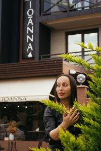 阿德勒Ioanna Boutique Hotel的站在建筑物前面的女人