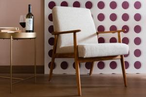沃卡罗Conca Bella Boutique Hotel & Wine Experience的一张桌子旁的白色椅子和一瓶葡萄酒
