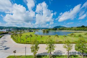 奈扬海滩Wyndham Royal Lee Phuket的一座拥有湖泊和棕榈树的公园