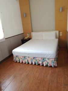 Hsin-hsien-ts'un富仙境的铺有木地板的小客房内的一张床位