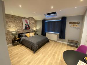 斯丹斯达蒙费雪特Modern Luxury 1 bed apartment with parking near Stansted Airport的一间卧室设有一张床和砖墙