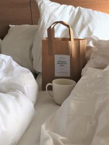哥本哈根萨沃亚酒店的纸袋和床上的杯子