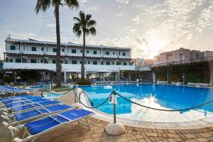丽都玛里尼Costa del Salento - CDSHotels的一个带躺椅的大型游泳池和一间酒店