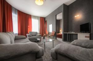 圣彼得堡第五角酒店的客厅配有两张沙发和一台电视