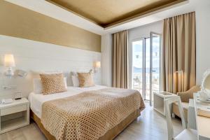 波连萨港Hotel Illa d'Or & Club Apts 4* Sup的酒店客房设有一张床和一个大窗户