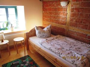 GlashütteFerienhof Herm的一间卧室设有一张床和砖墙