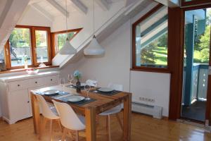 基姆湖畔贝尔瑙Ferienwohnung Bernau的一间带木桌和椅子的用餐室