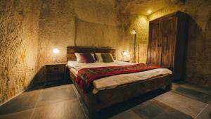 内夫谢希尔Cappadocia Old Houses的一间卧室配有一张带木制床头板的床