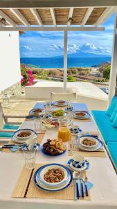 卡拉法蒂斯Thalia Myconian Suites的一张带食物盘的桌子,享有海景