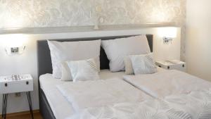 哈尔伯施塔特Rosenwinkel Appartement im OG的一张带白色床单和枕头的床