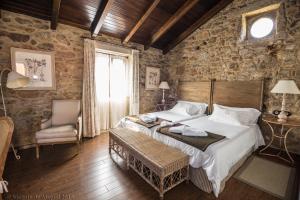 卡马里尼亚斯卢加尔多克塔里尼欧乡村酒店的卧室配有一张石墙内的大床