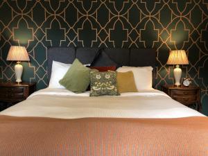 灵伍德Moortown Lodge B&B的一间卧室配有一张大床、枕头和两盏灯。