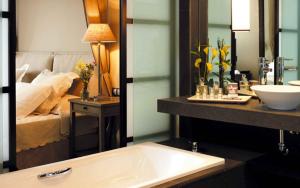 菲内斯特拉特亚洲花园酒店及泰国水疗中心 - 皇家隐居酒店的一间带水槽的浴室和一张位于后面的床。