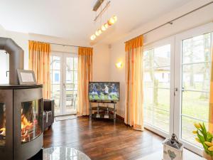 ZirchowReetdachhaus mit Sauna, Kamin & Terrasse - D 028.032的客厅设有壁炉和电视。