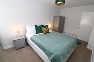 蒂斯河畔斯托克顿The Lodge IHMELB - APARTMENT 4的一间卧室配有一张带绿色棉被的床