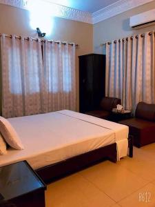 卡拉奇Cosy Inn Guest House Karachi的一间卧室配有一张大床和一张沙发