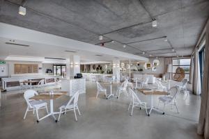 AmsterdamhoekBluewater Bay Sunrise Hotel的用餐室配有桌子和白色椅子