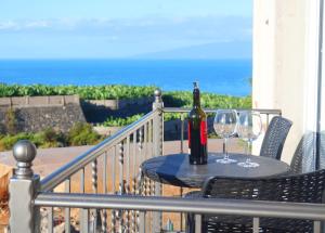 圣胡安海滩Casa Tranquila的阳台上的桌子上放有一瓶葡萄酒和两杯酒