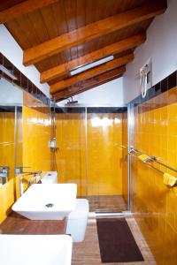 派瓦堡Family Room - Quinta do Mirante的浴室设有水槽和黄色瓷砖淋浴。