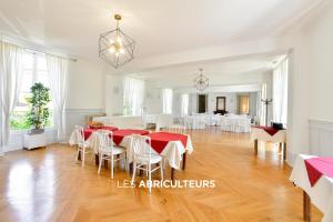 莫里尼尚皮尼诺维勒·德维勒马丁旅馆的一间设有红色桌子和白色椅子的用餐室