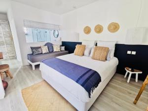 马勒勒角The Good Life Eco Lodges - Serenity & Wellness Resort - Adult only的一间卧室配有一张大床和一张沙发
