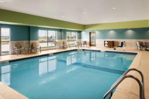 西得梅因Holiday Inn Express & Suites - West Des Moines - Jordan Creek, an IHG Hotel的蓝色的大游泳池,位于酒店客房内