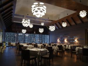 Beloe Ozero格林伍德酒店的用餐室配有桌椅和吊灯。