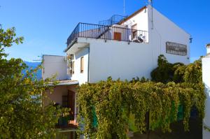 阿尔戈多纳莱斯EcoAlbergue Rural de Algodonales的带阳台和藤蔓的白色建筑