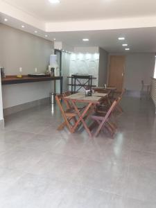 沙帕达-杜斯吉马朗伊斯POUSADA DA MAGA的一间铺有瓷砖地板并配有桌椅的用餐室