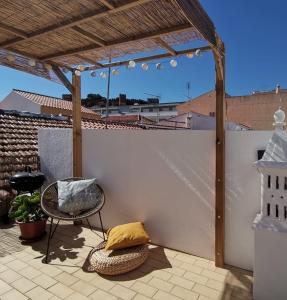 西尔韦斯Algarve house, sun, terrace, views and barbecue的一个带凉棚、椅子和桌子的庭院