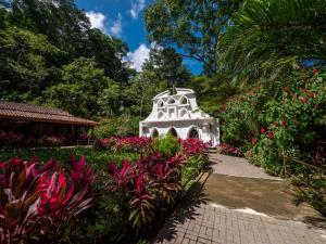 雅科Villa Lapas Jungle Village的花卉花园中的白色建筑